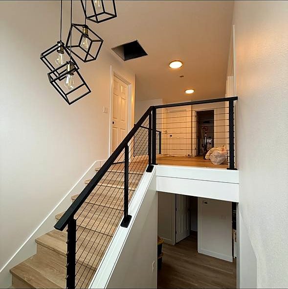 Cable railing staircase with pendant cluster above the landing
