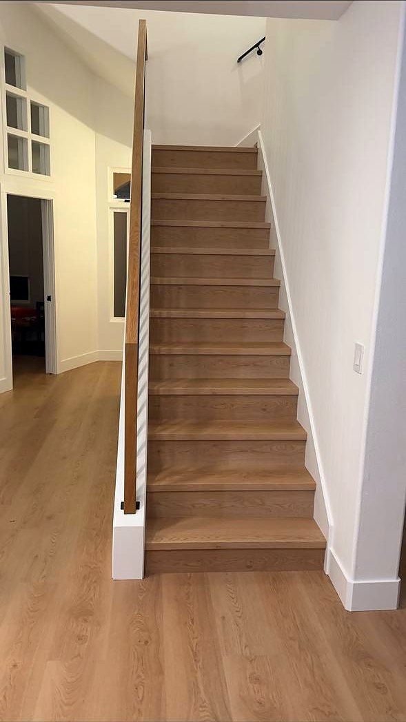 Straight oak stair run with wall-mounted handrail