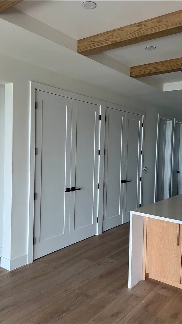 Grey shaker doors under a wood beam ceiling