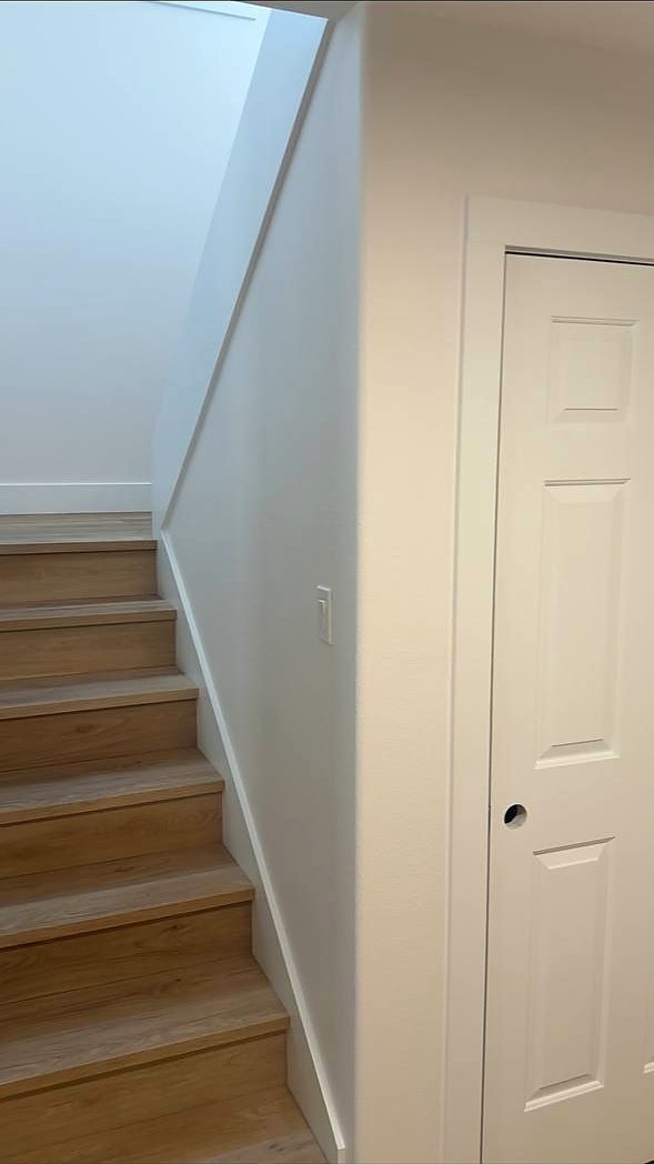 White oak stair treads beside a painted interior door